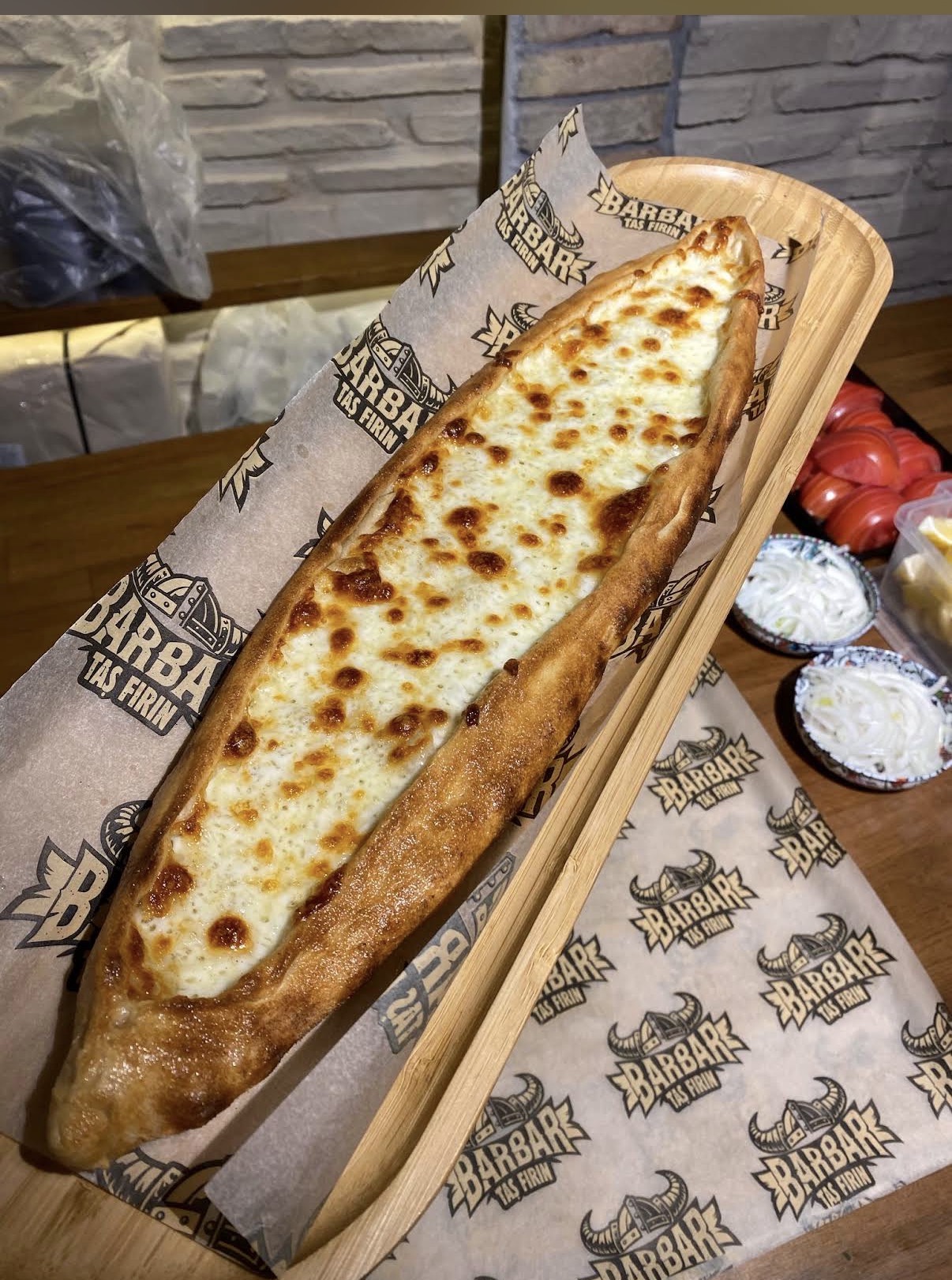 Long cheese pide on a wooden serving board